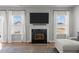 Cozy living room featuring a fireplace with a white mantel, a mounted TV, and large windows at 350 Arlie Ln, Lillington, NC 27546