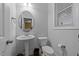 Powder room featuring a pedestal sink, toilet, and window at 363 Grey Hawk Dr, Garner, NC 27529