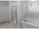 Bright bathroom features a soaking tub, glass-enclosed shower, and white tiling at 363 Grey Hawk Dr, Garner, NC 27529