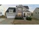 Charming two-story home featuring gray siding, stone accents, and a welcoming front porch with manicured landscaping at 363 Grey Hawk Dr, Garner, NC 27529