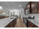 Open-concept kitchen features granite counters, stainless appliances, and a view into the dining and living area at 363 Grey Hawk Dr, Garner, NC 27529