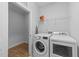 Functional laundry room includes a washer, dryer, storage shelving, and wood-look flooring at 363 Grey Hawk Dr, Garner, NC 27529