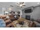 Open-concept living room features a fireplace, ceiling fan, and comfortable brown sectional sofa at 363 Grey Hawk Dr, Garner, NC 27529