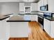 Modern kitchen with white cabinets, black countertops and stainless steel appliances at 4023 Cashew Dr, Raleigh, NC 27616
