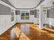 Spacious living room boasts gleaming hardwood floors, grey walls, and a large bright window at 4023 Cashew Dr, Raleigh, NC 27616