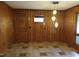 Spacious dining area featuring wood paneled walls, tile floors, updated lighting, and a front door at 410 W Barrington St, Dunn, NC 28334