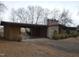 Side view of a single-story brick home with a covered carport and mature trees at 410 W Barrington St, Dunn, NC 28334