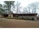 Front exterior view of a brick home with a covered carport and mature trees at 410 W Barrington St, Dunn, NC 28334