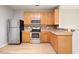 Well-lit kitchen features stainless steel appliances, wooden cabinetry, and ample counter space at 4201 Hampstead Village Dr, Durham, NC 27703