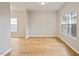 Inviting living room with large windows that illuminate the hardwood floors at 4201 Hampstead Village Dr, Durham, NC 27703