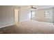 Expansive main bedroom with neutral carpet, ceiling fan, and natural light from two windows at 4201 Hampstead Village Dr, Durham, NC 27703