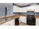 Kitchen with white cabinets, dark countertops, and black appliances at 521 Eastway Ave # Apt B, Durham, NC 27703
