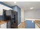 Kitchen with black appliances, white cabinets and view to the dining area at 521 Eastway Ave # Apt B, Durham, NC 27703