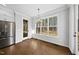 Bright breakfast nook with hardwood floors, stainless appliances, and large windows with scenic backyard views at 5609 Abbey Grace Ln, Wake Forest, NC 27587