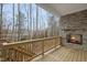 Covered porch with a stone fireplace and a view of the wooded backyard at 616 Long Lake Dr, Fuquay Varina, NC 27526