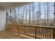Relaxing back porch with wood railing and a scenic view of the surrounding woods at 616 Long Lake Dr, Fuquay Varina, NC 27526