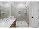 This bathroom boasts a luxurious walk-in shower and a single sink vanity with neutral tile at 616 Long Lake Dr, Fuquay Varina, NC 27526