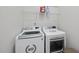 Bright laundry room features a front load washer and dryer and a shelf for laundry supplies at 616 Long Lake Dr, Fuquay Varina, NC 27526