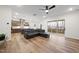 Open-concept living room with hardwood floors, a comfortable sectional sofa, and a kitchen view at 616 Long Lake Dr, Fuquay Varina, NC 27526