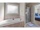 Bathroom featuring a soaking tub under a window and a separate glass shower at 64 Old Barn Way, Wendell, NC 27591