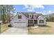 Charming two-story home with attached garage and well-maintained lawn on a sunny day at 64 Old Barn Way, Wendell, NC 27591