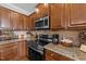 Cozy kitchen featuring wood cabinetry, granite countertops, stainless steel appliances and neutral backsplash at 64 Old Barn Way, Wendell, NC 27591