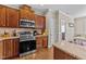 A well-equipped kitchen featuring stainless steel appliances and plentiful dark wood cabinetry at 64 Old Barn Way, Wendell, NC 27591