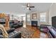 Open-concept living room with hardwood floors, fireplace, multiple windows, and adjacent kitchen and dining areas at 64 Old Barn Way, Wendell, NC 27591