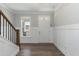 Bright entryway showcasing hardwood floors, wainscoting, and a view to the front door at 76 Freewill Pl, Raleigh, NC 27603