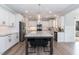 Modern kitchen features a large island with gray cabinetry, white cabinets, and stainless steel appliances at 76 Freewill Pl, Raleigh, NC 27603