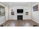 Bright living room featuring a fireplace, tv, modern paneling and hardwood floors at 76 Freewill Pl, Raleigh, NC 27603