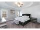 Bright main bedroom featuring a tray ceiling, two windows and accent wall panels at 76 Freewill Pl, Raleigh, NC 27603