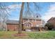 A beautiful backyard with a well-manicured lawn, lovely deck, and charming brick facade at 810 Warwick Ct, Burlington, NC 27215