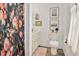 Bathroom featuring a shower with a floral curtain, toilet, and framed art against a neutral color palette at 810 Warwick Ct, Burlington, NC 27215