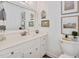 Bright bathroom features a single vanity with a framed mirror and framed art above the toilet against a neutral color palette at 810 Warwick Ct, Burlington, NC 27215
