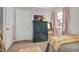 Cozy bedroom featuring a green cabinet with gold accents, soft carpet and warm lighting at 810 Warwick Ct, Burlington, NC 27215
