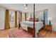 Spacious bedroom with hardwood floors, area rug, and a unique four-poster bed in front of an accent wall map at 810 Warwick Ct, Burlington, NC 27215