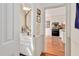 Hallway view of half-bathroom and kitchen with white cabinets and appliances at 810 Warwick Ct, Burlington, NC 27215