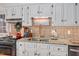 Updated kitchen with white cabinets, stainless steel sink and backsplash, and granite countertop at 810 Warwick Ct, Burlington, NC 27215