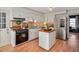 Bright kitchen featuring white cabinets, stainless steel appliances and a functional center island at 810 Warwick Ct, Burlington, NC 27215