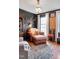 A cozy living room featuring dark walls, wood trim, chandelier, and natural light from the window at 810 Warwick Ct, Burlington, NC 27215