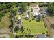 Expansive aerial view of a property featuring lush greenery, multiple houses, outbuildings, and silos on a well-maintained lot at 8324 Humie Olive Rd, Apex, NC 27502