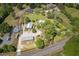 Aerial view of estate highlighting property lines, multiple buildings, expansive lawns, mature trees and road access at 8324 Humie Olive Rd, Apex, NC 27502