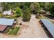Aerial view features barns, garages, and gravel driveway surrounded by lush trees and manicured landscaping at 8324 Humie Olive Rd, Apex, NC 27502