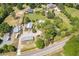A sprawling property with multiple houses, barns, outbuildings, and a large lot surrounded by lush greenery and a road at 8324 Humie Olive Rd, Apex, NC 27502