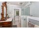 Bathroom featuring a dark wood vanity, a shower with glass door, and access to the outdoors at 8324 Humie Olive Rd, Apex, NC 27502