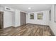Neutral bedroom featuring wood laminate flooring, base trim and natural light from the windows at 8324 Humie Olive Rd, Apex, NC 27502