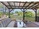 Relaxing covered deck with comfortable seating, a coffee table, and a view of the expansive backyard at 8324 Humie Olive Rd, Apex, NC 27502