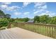 Outdoor deck with wooden railings and a view of the expansive backyard and mature trees at 8324 Humie Olive Rd, Apex, NC 27502