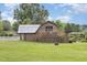 Large backyard with a fire pit, barn, and a charming garden gazebo at 8324 Humie Olive Rd, Apex, NC 27502